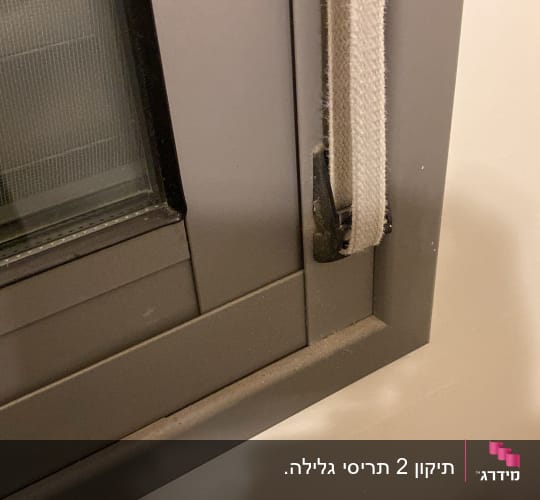 מסגרת חלון עם תריסים וחבל משיכה